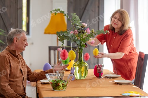 Preview: Grandparents decorate a bouquet of flowers at an Easter lunch sitting at the table at home