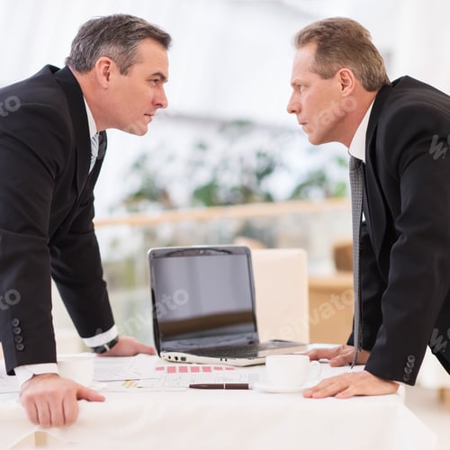 Preview: Business confrontation. Two mature men in formalwear conflicting while standing face to face
