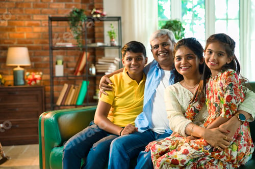 Preview: Cheerful Indian Asian family poses for a close-up photo while sitting on the sofa