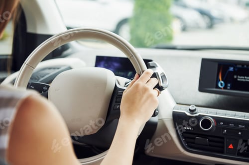 Preview: Close up view. Female driver inside of modern automobile. Testing brand new car