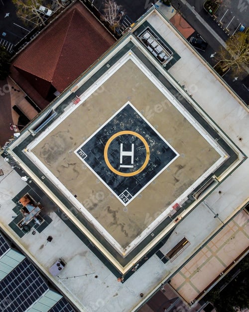Preview: Vertical top view of a helipad on the top of a high building in an urban area
