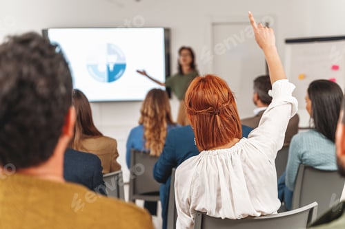 Preview: Red-haired Woman Raising Hand during Business Presentation