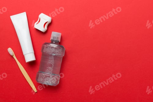 Preview: Mouthwash and other oral hygiene products on colored table top view