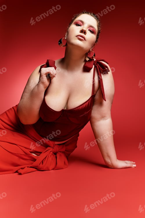 Preview: Stylish young woman poses confidently in a bold red dress against a vibrant backdrop