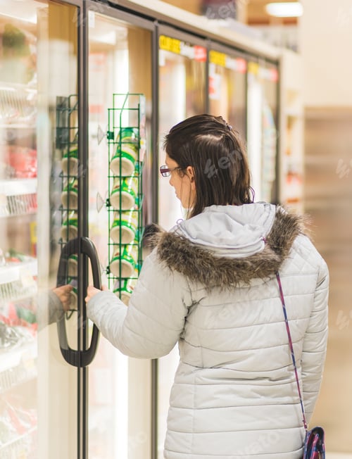 Preview: young millennial woman at the grocery store in the produce aisle