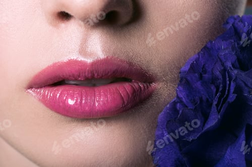 Preview: partial portrait of beautiful young woman with pink lips and purple eustoma flower