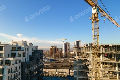 Preview: Aerial view of high tower crane and residential apartment buildings under construction.