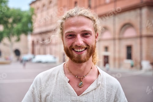 Preview: Portrait of attractive smiling young man looking at camera in park. Caucasian male handsome model.