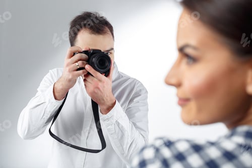 Preview: Facing a camera during a photoshoot in a studio with two people engaged in the activity