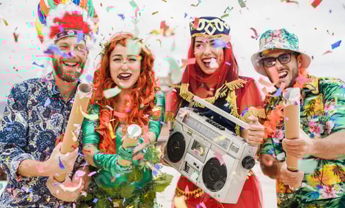 Aperçu: Des gens habillés et heureux célébrant une fête de carnaval en lançant des confettis - Concentrez-vous sur les mains gauches des filles