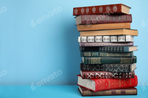 Preview: Stack of hardcover books on light blue background, space for text