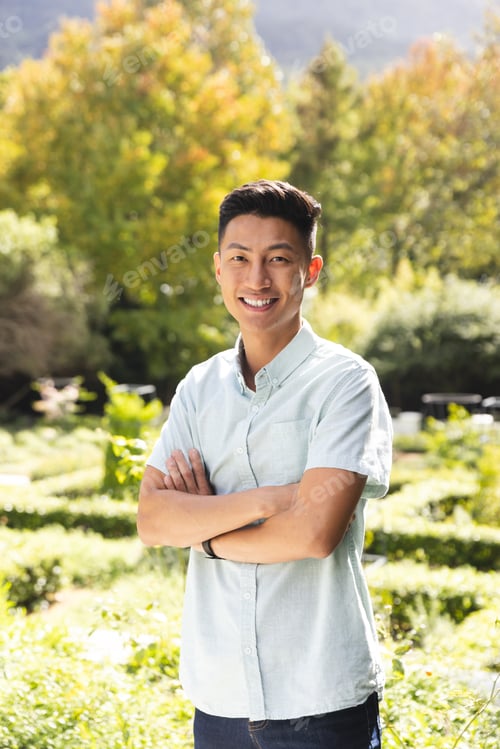 Preview: Portrait of happy asian man smiling in sunny garden