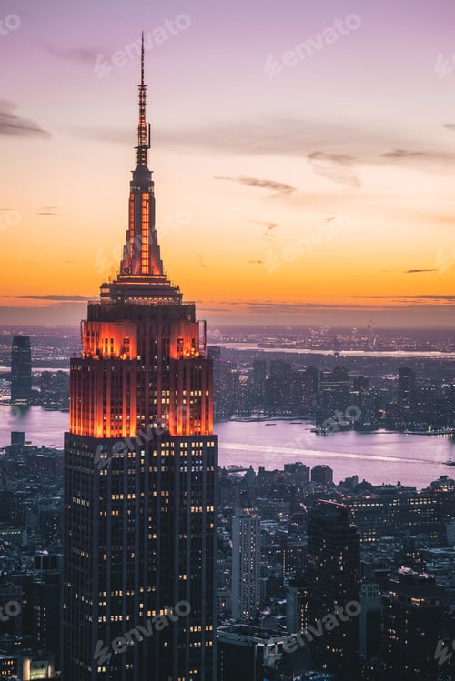 Preview: Bird's eye view of skyscrapers and Empire State Building illuminated at sunset in New York, USA