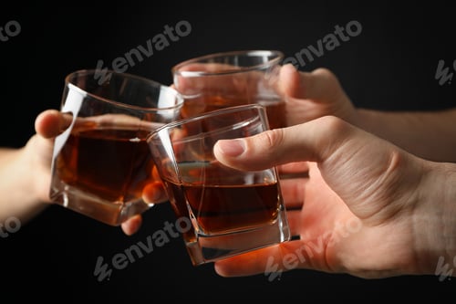 Preview: Three male hands holds glasses of whiskey on black background, close up. Cheers