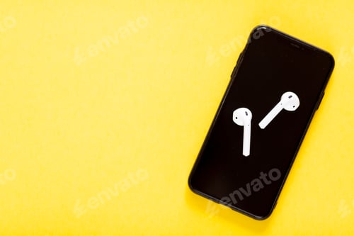 Preview: Flat lay with smartphone and wireless headphones on yellow background with copy space