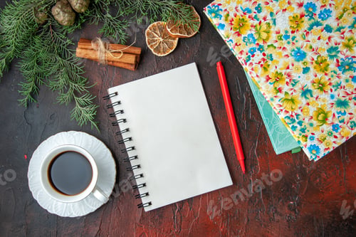 Preview: Horizontal view of a cup of blck tea closed notebook with pen cinnamon limes a ball of rope and