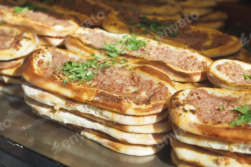 Preview: Delicious flatbreads topped with seasoned minced meat and fresh herbs at a street food vendor