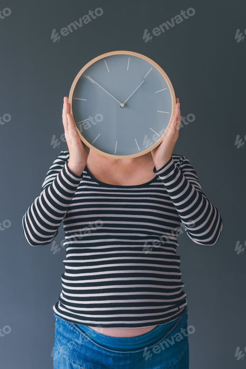 Preview: Pregnant female with vintage alarm clock