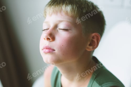 Preview: Portrait of a cute caucasian boy with closed eyes. Teenager is meditating.