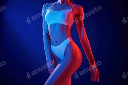 Preview: Close up view. Young woman in underwear is in the studio with neon lights