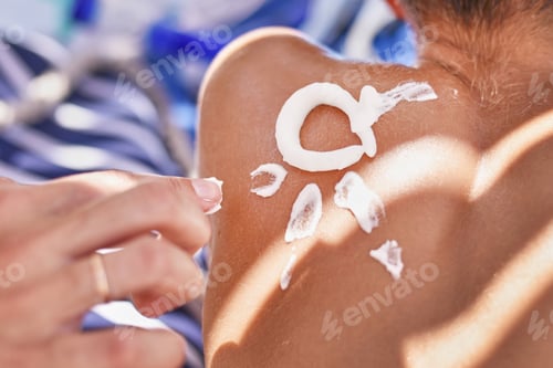 Preview: Woman apply protective sunscreen on the boy's shoulders skin