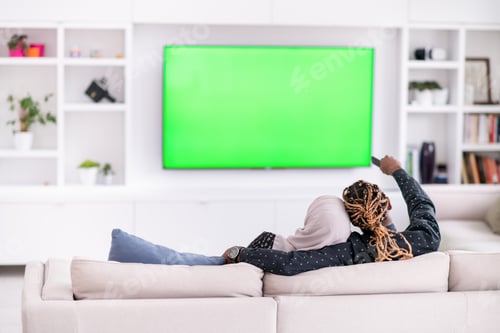 Preview: African Couple Sitting On Sofa Watching TV Together