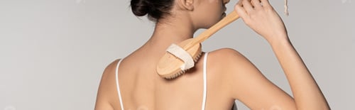 Preview: panoramic shot of woman using massage brush, isolated on grey