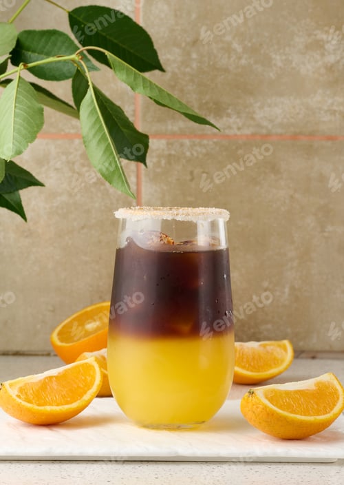 Preview: Cold coffee with orange juice in a transparent glass and orange slices