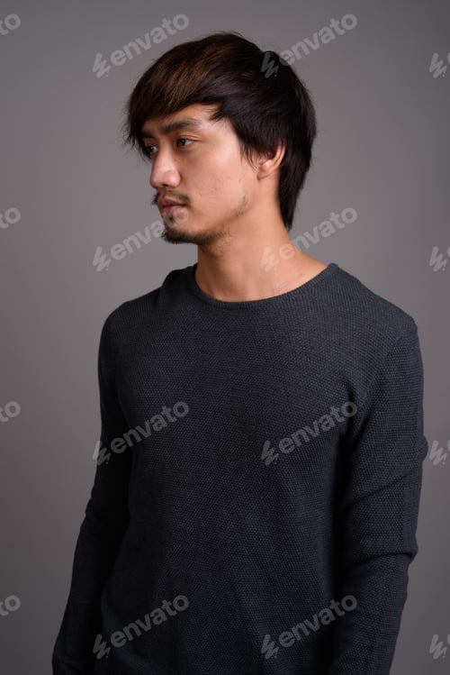 Preview: Young Asian man against gray background