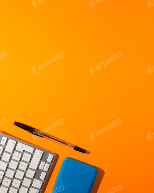 Preview: Vertical shot of a smartphone and a keyboard with a pen on an orange background