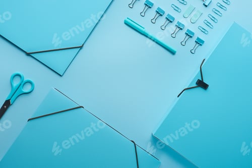 Preview: flat lay of paper folders and various stationery isolated on blue