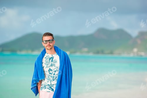 Preview: Young man on white sandy beach on vacation