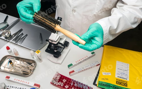Preview: police scientist holding hairbrush in crime lab, conceptual image