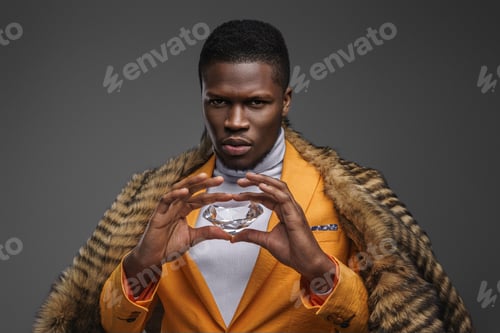 Preview: Dapper dark-skinned man showcasing an enormous diamond on a gray background