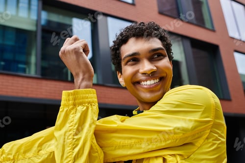 Preview: Sporty young individual enjoying a moment of joy outdoors in urban surroundings