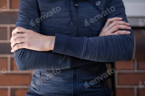 Preview: Person in Blue Jacket With Arms Crossed
