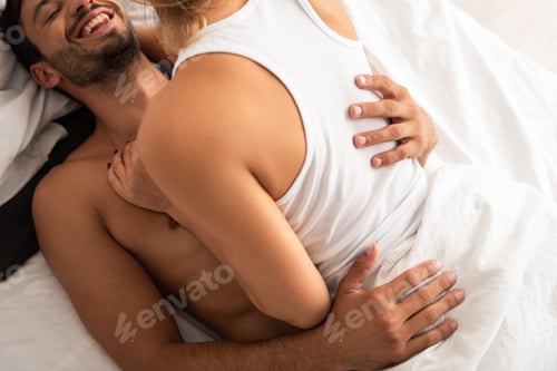 Preview: smiling couple hugging in bed in the morning