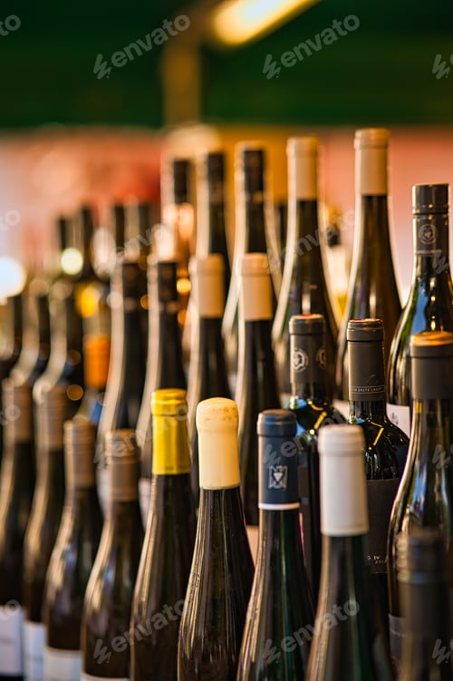 Preview: Vertical shot of wine bottles, displayed in a winery shop on a blurred background