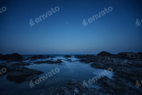 Preview: Starry sky above a rocky coastline