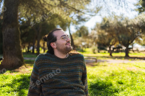Preview: Young man relaxing in a park enjoying sunny day