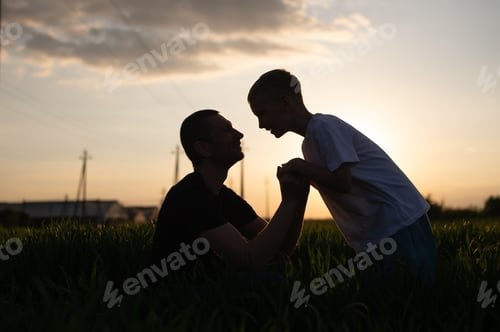 Preview: dad and son holding hands at sunset