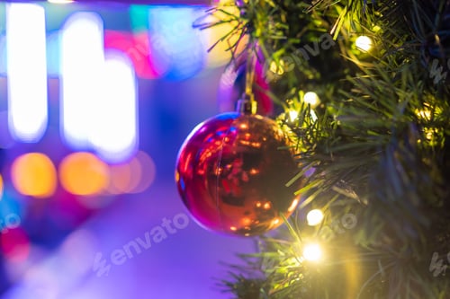 Preview: Closeup of the red bauble of a Christmas tree on a bokeh lights background