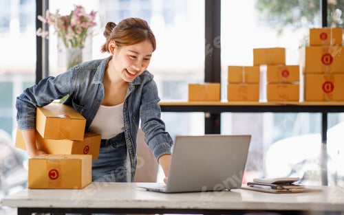 Preview: Startup small business entrepreneur or freelance Asian woman using a laptop with box, Young success