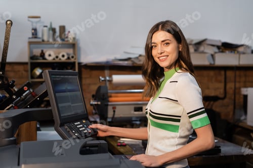 Preview: cheerful publisher pressing button on panel while working in print center