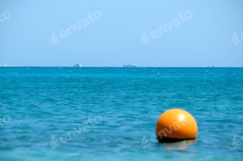 Preview: Seascape with ripple surface of blue sea water with distant ships floating on calm waves.