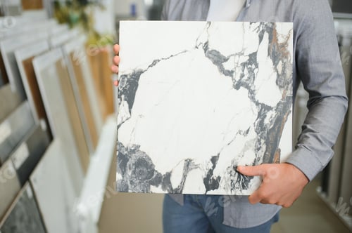 Preview: architect or interior designer choosing ceramic texture sample from swatch board in design studio