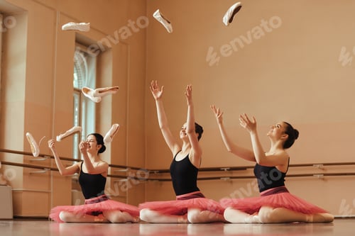 Preview: Happy ballerinas throwing ballet pumps in the air and having fun at dance studio.
