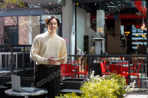 Preview: Smiling asian man using digital tablet, standing in modern cafe, remote work, male looking at camera