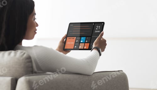 Preview: Black woman holding digital tablet with smart home app