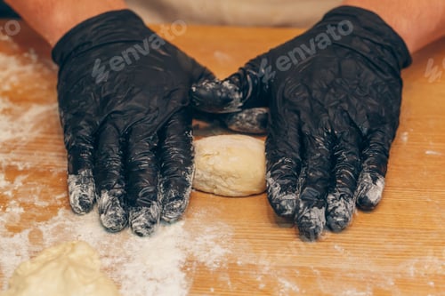 Preview: Chef hands in black gloves prepares dough close up